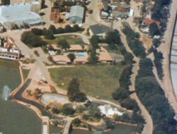 Aerial view (from Inside Universal Studios, 1973) showing Park Lake and the Riverboat on the left, the blue Motel swimming pool can be seen centre with the LA River flood channel on the right